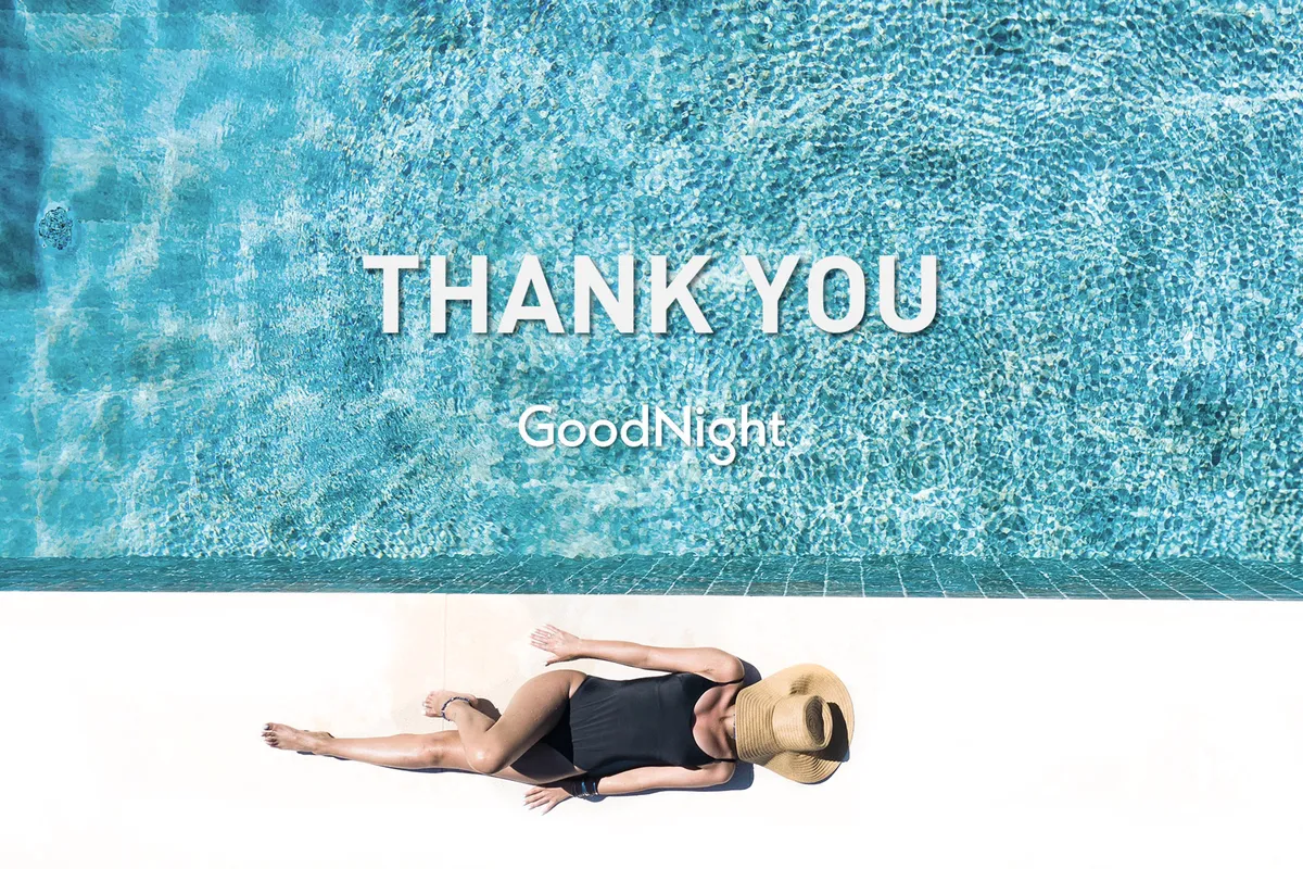 An inviting view of a serene swimming pool with a person lounging poolside during twilight. The sky is tinged with the last light of day, and the scene suggests relaxation and reflection after a day of activity.