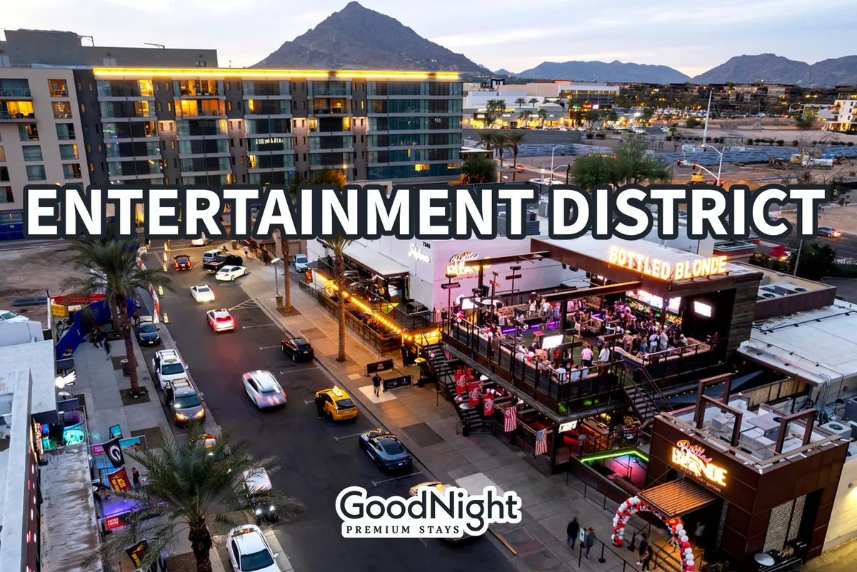 The image depicts a lively Scottsdale street scene featuring entertainment venues, bustling pedestrian activity, and a scenic mountain backdrop. The energetic atmosphere captures the nightlife and vibrant social scene for which Old Town is known.